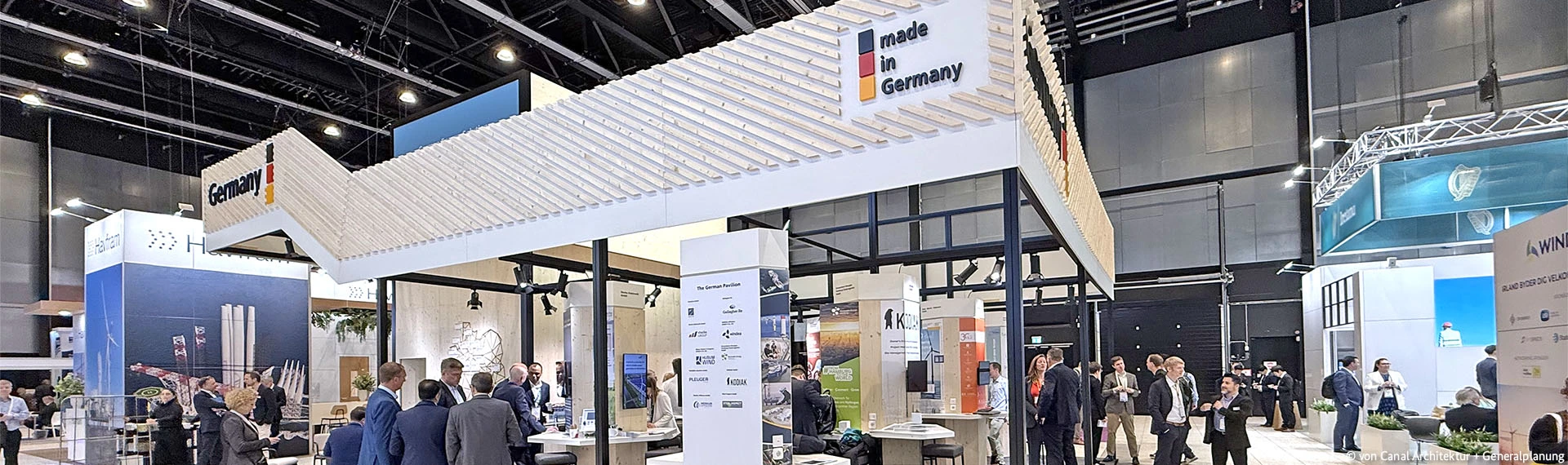 German Pavilion exhibition booth at an international trade fair, showing the “Germany” signage and the “Made in Germany” logo, with visitors walking through the exhibition hall.